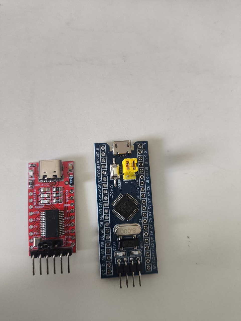 The HW-417C USB-UART adapter and the STM32 Blue Pill side by side on a desk