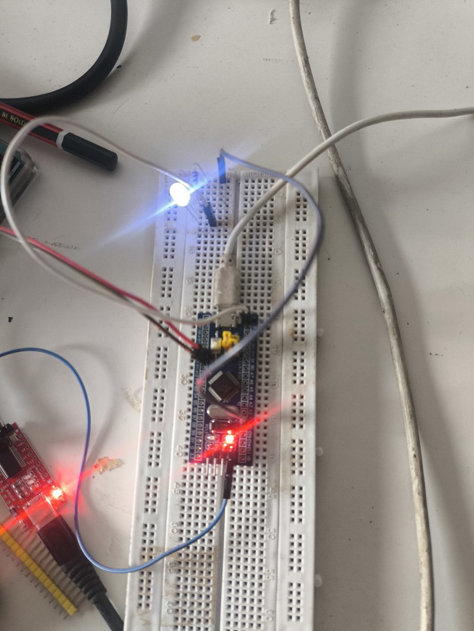 The LED on the breadboard glowing near peak brightness partway through the fade